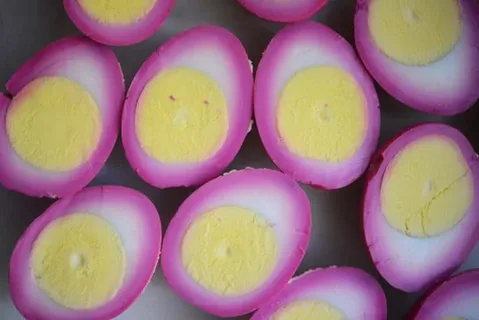 Uova sode tagliate a metà con albume rosa colorato da barbabietola, fonte di vitamina B12